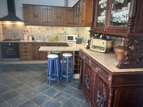a kitchen with a counter and stools in it at Casa dos Avós in Campinho