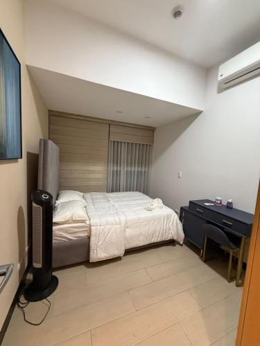 a bedroom with a bed and a desk in it at Luxury Executive Suites 3 Bedroom Condo Uptown Parksuites Tower 1 in Manila