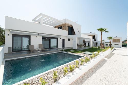 a house with a swimming pool in front of it at Emerald Island Residential Complex in Skala Rachoniou