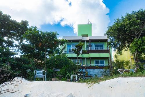 a building on the beach with chairs and trees at Sion fusaki Beachfront in Ishigaki Island