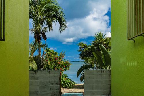 a view of the ocean from a green building at Sion fusaki Beachfront in Ishigaki Island