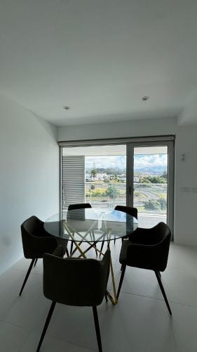 a dining room with a glass table and chairs at Atlantic Golden View Luxe Apartment in Ponta Delgada