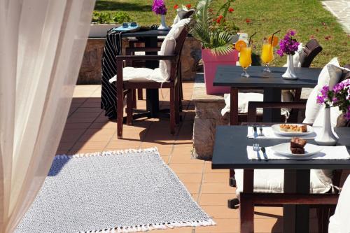 a patio with tables and chairs with drinks on it at Vigles Sea View, Philian Hotels and Resorts in Skiathos Town