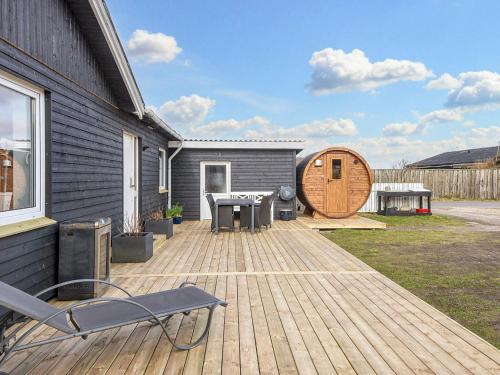 a deck with a table and chairs on a house at Luxury Spa Retreat in Thorsminde - By Traum Ferienwohnungen in Ulfborg