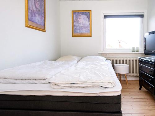 an unmade bed in a bedroom with a television at Luxury Spa Retreat in Thorsminde - By Traum Ferienwohnungen in Ulfborg