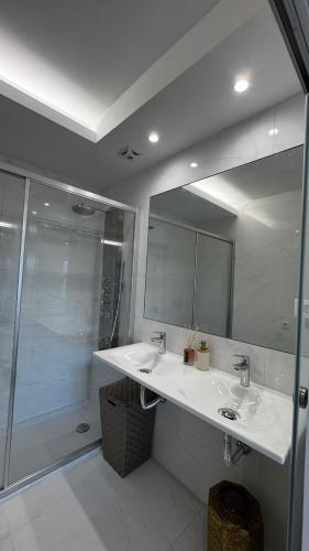 a bathroom with a sink and a shower and a mirror at Atlantic Golden View Luxe Apartment in Ponta Delgada