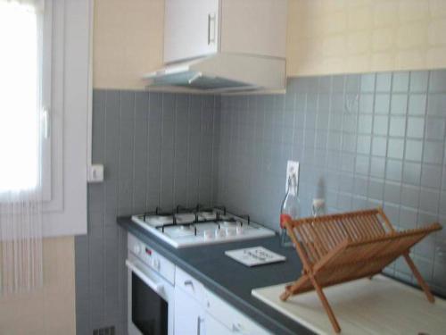 - une cuisine avec un évier et un banc dans l'établissement Maison pour 4 personnes, à Port-en-Bessin-Huppain