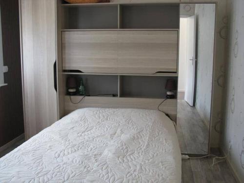 une chambre avec un lit blanc dans une pièce dans l'établissement Maison pour 4 personnes, à Port-en-Bessin-Huppain