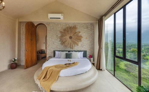 a bedroom with a large bed with a large window at SaffronStays Roman Holiday in Jambrung 