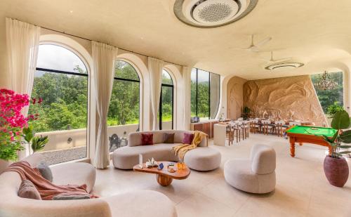a large living room with a pool table and chairs at SaffronStays Roman Holiday in Jambrung 