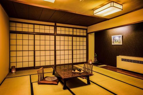 a room with a table and chairs and a window at Ooedo Onsen Monogatari Gero Bekkan in Gero