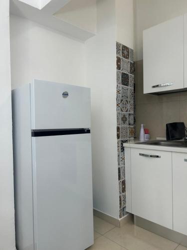 a white refrigerator in a kitchen next to a counter at Blue House in Santa Maria La Carità