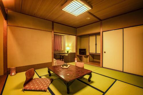 a room with a table and chairs in a room at Ooedo Onsen Monogatari Gero Bekkan in Gero