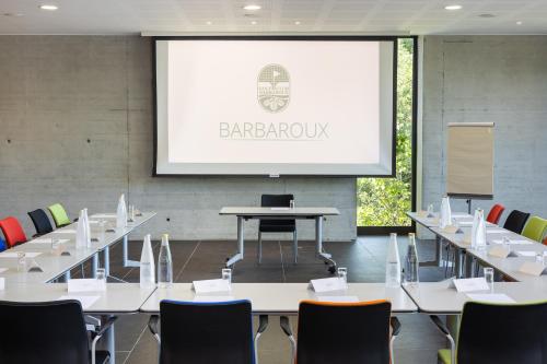 a conference room with tables and chairs and a projection screen at Mercure Brignoles Golf de Barbaroux & Spa in Brignoles