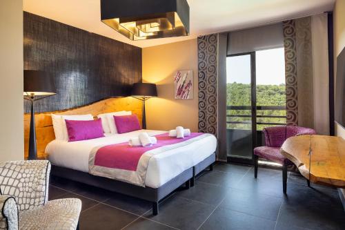 a bedroom with a large bed with pink pillows at Mercure Brignoles Golf de Barbaroux & Spa in Brignoles