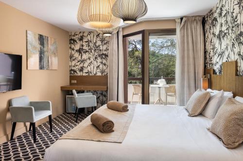 a bedroom with a large white bed and a window at Mercure Brignoles Golf de Barbaroux & Spa in Brignoles