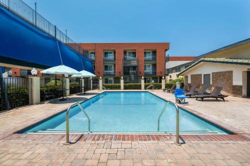 a swimming pool in front of a building at Travelodge Inn & Suites by Wyndham Anaheim on Disneyland Dr in Anaheim