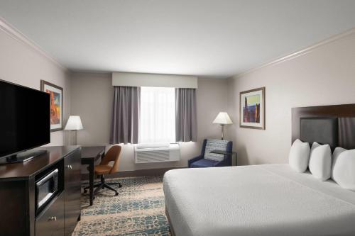 a hotel room with a bed and a desk and a television at La Quinta by Wyndham Moab in Moab