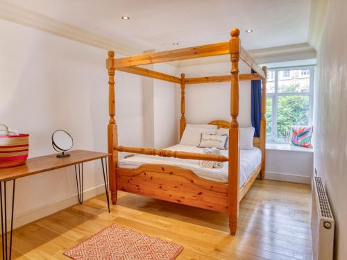 a bedroom with a wooden four poster bed at Central Penthouse Apartment Pass The Keys in Lincoln