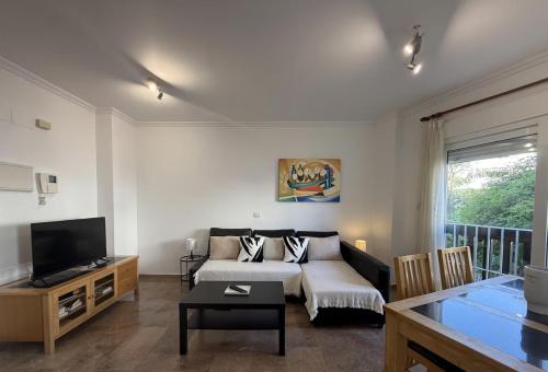 a living room with a couch and a television at Apartamento en Puerta del mar con piscina y wifi - PUERTA DEL MAR CALAHONDA in Mijas Costa