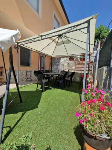 a patio with a table and chairs and an umbrella at La Casa del Ciliegio in Teana