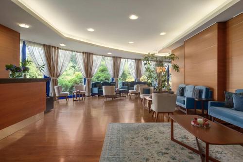a waiting room at a hospital with chairs and tables at Dolce by Wyndham Milan Malpensa in Somma Lombardo