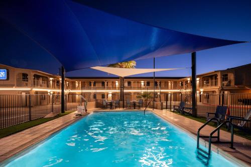 a large swimming pool with a large umbrella over it at Travelodge by Wyndham Parker in Parker