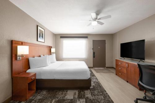 a hotel room with a bed and a flat screen tv at Travelodge by Wyndham Parker in Parker