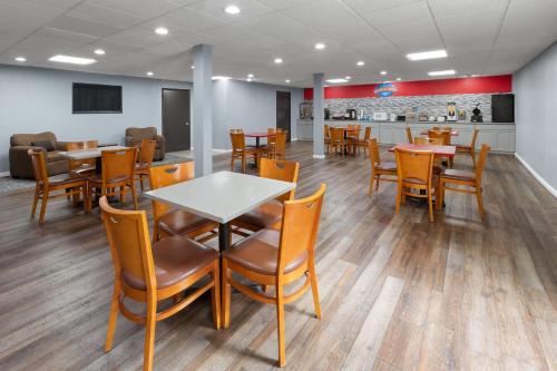 une salle à manger avec tables et chaises et un bar dans l'établissement Baymont by Wyndham Iron Mountain, à Iron Mountain