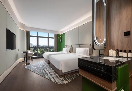 a bedroom with a bed and a sink and a mirror at Wingate by Wyndham Xi'an Chanba in Xi'an