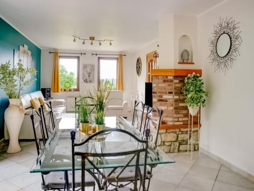 a dining room and living room with a glass table and chairs at Family Escape with Pool in Filot