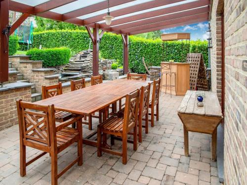 a wooden table and chairs on a patio at Family Escape with Pool in Filot