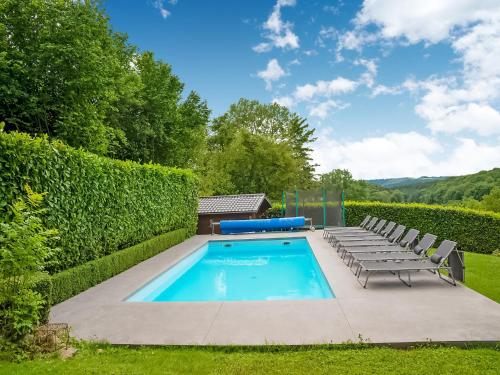 a swimming pool with lounge chairs next to a hedge at Family Escape with Pool in Filot