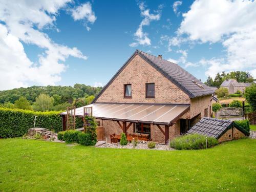 a brick house with a metal roof on a green field at Family Escape with Pool in Filot