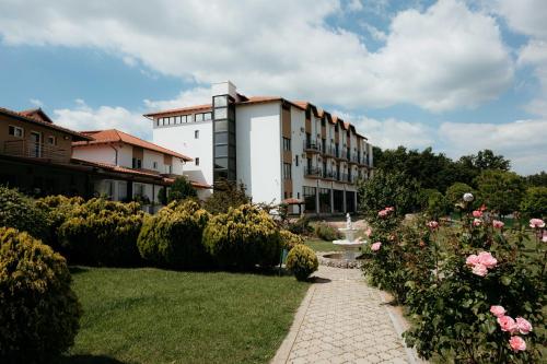 a building with a garden with roses in front of it at Vila Aleksandar in Orašac