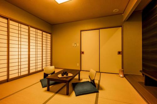 a room with a table and chairs and a door at Ooedo Onsen Monogatari Premium Seiunkaku in Awara