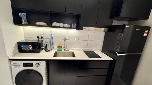 a small kitchen with a sink and a microwave at Axon Residence Near Fehrenheit Bukit Bintang in Kuala Lumpur