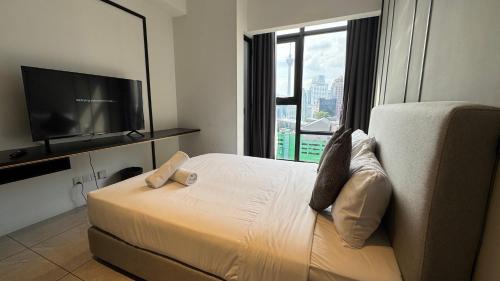 a hotel room with a bed and a flat screen tv at Axon Residence Near Fehrenheit Bukit Bintang in Kuala Lumpur
