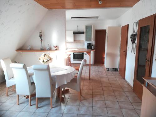 a kitchen and dining room with a white table and chairs at Wohnung in Silbecke mit Pool und Wald in Attendorn