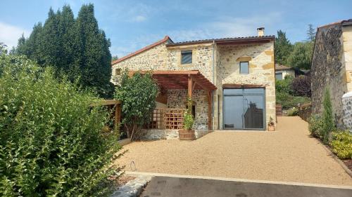 a stone house with a garage in front of it at Gite Du Buisson in Parent