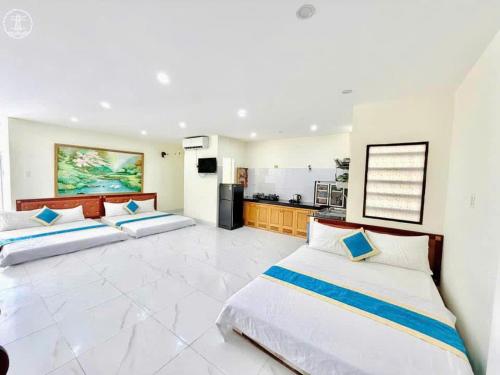 ブンタウにあるAn Khang Hotel Vung tauのキッチン付きの広い部屋にベッドが2つあります