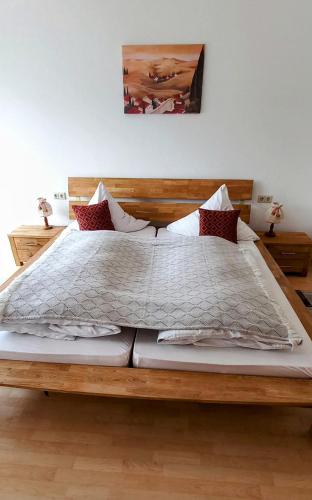 a bedroom with a large bed with a wooden frame at Pension Ochsen, Ferienwohnungen in Löffingen