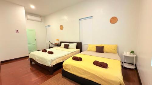 two beds in a room with white walls at 3BR 5BedVilla Silom China town BTS Surasak Special offer in Chinatown