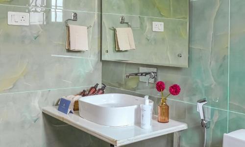 a bathroom with a white sink and a mirror at Badakshan Bliss in Srinagar