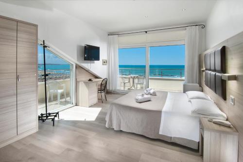a bedroom with a bed and a view of the ocean at Hotel Bellevue in Cattolica