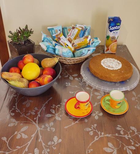 a table topped with a bowl of fruit and a cake at Tana Libera Tutti 3 Nature, Yourself, Love in Viggianello