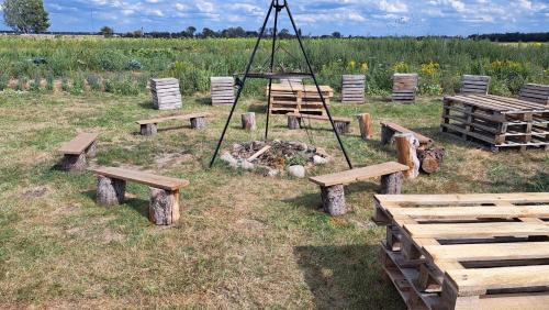 a group of benches and a fire in a field at Dom przy Lawendowej Altanie in Kosow