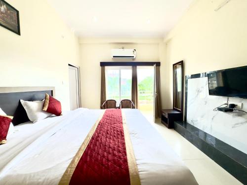 a bedroom with a large bed and a tv at Nath Palace in Varanasi