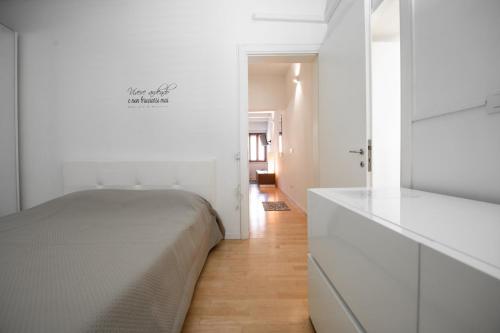 a white bedroom with a bed and a hallway at B-Suite Pesaro, Mare & Stile in Pesaro