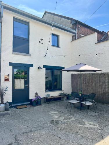 a patio with a table and an umbrella at La maison de MiLy in Bassenge